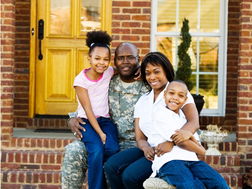 military family in front of house
